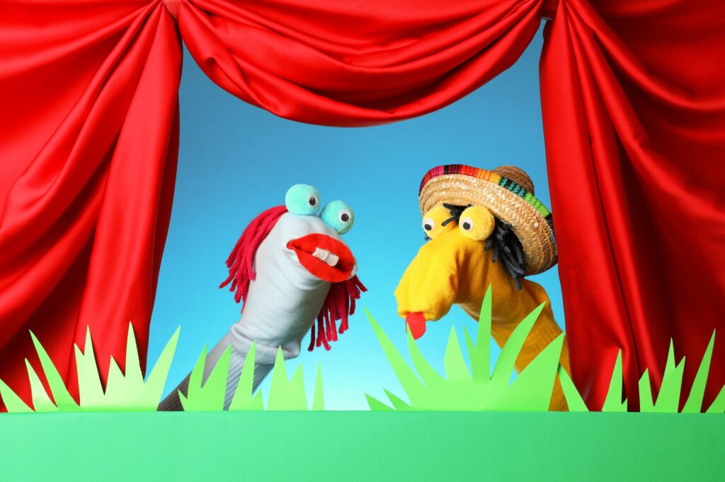 Creative puppet show on stage with decorations and red curtains